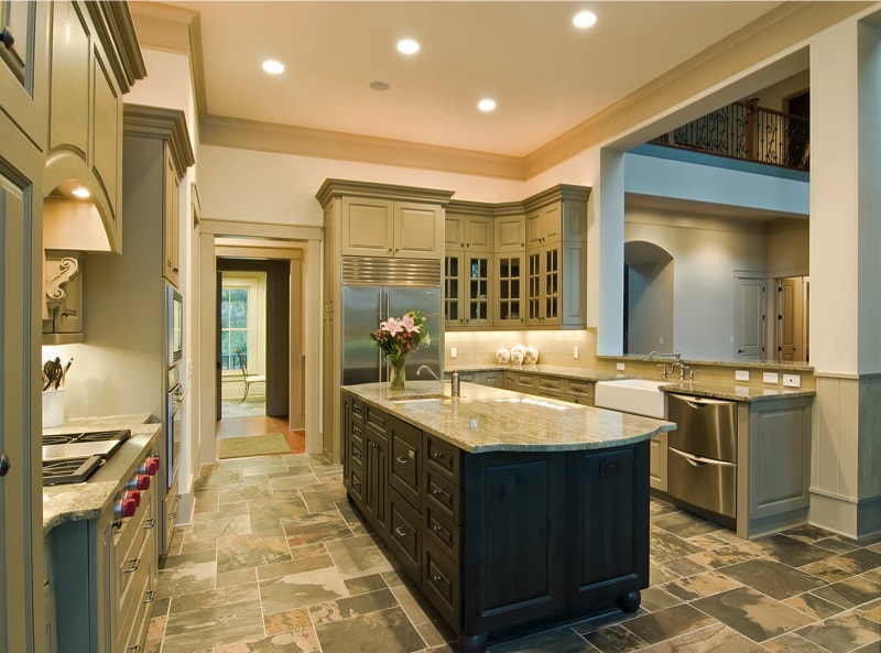 This expensive kitchen interior has granite counters and a slate floor.