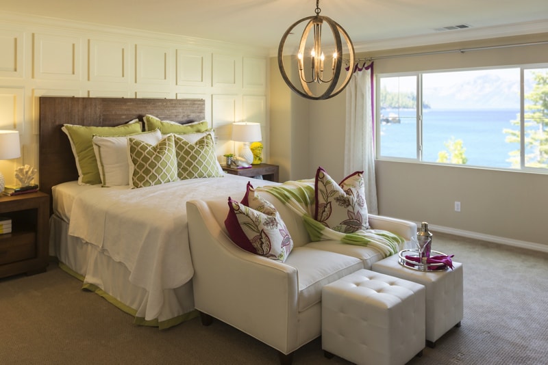 Beautiful master bedroom with light yellow tones, seating area and an expansive view